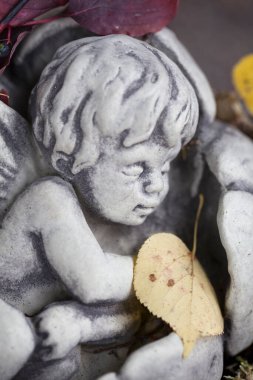 Taştan yapılmış küçük uyuyan melek figürü.