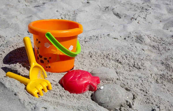 ビーチの砂の中にカラフルなプラスチック製のおもちゃ — ストック写真