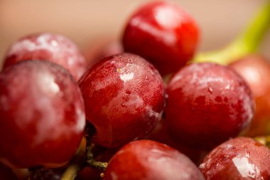 Taze kırmızı lezzetli vegan organik üzümler ve su damlaları.