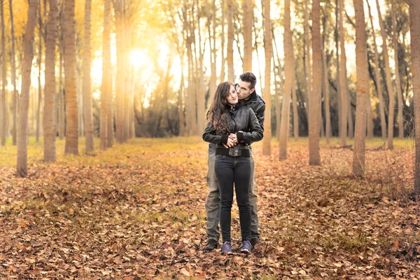 Casal romântico vestindo jeans andando no parque de outono Fotos De Bancos De Imagens