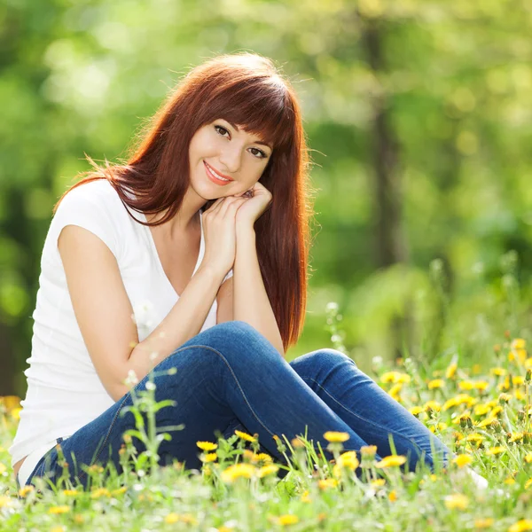 Young woman in the park with flowers — Stock Photo, Image