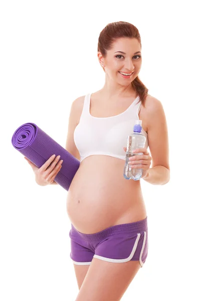 Hermosa mujer embarazada con esterilla de ejercicio y agua en blanco — Foto de Stock