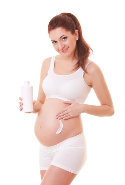 漂亮的孕妇应用在她的身体上的奶油。孤立在 wh — 图库照片