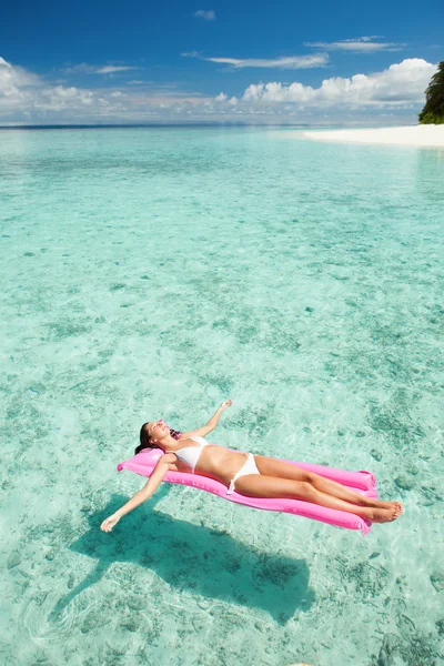 Жінка розслабляється на надувному матраці в морі — стокове фото