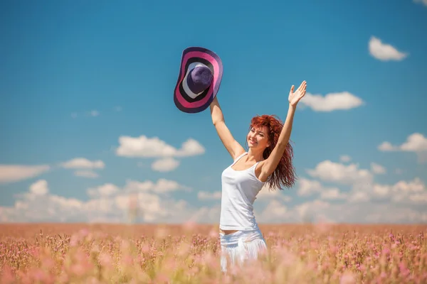 Vrouw in het veld met bloemen — Stockfoto