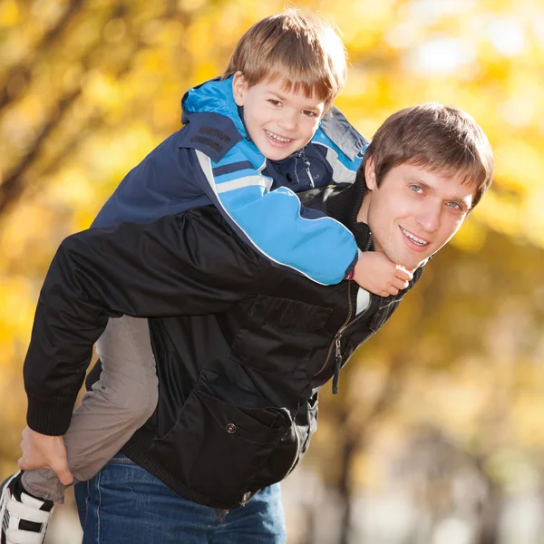 Šťastný otec a jeho syn v podzimním parku — Stock fotografie