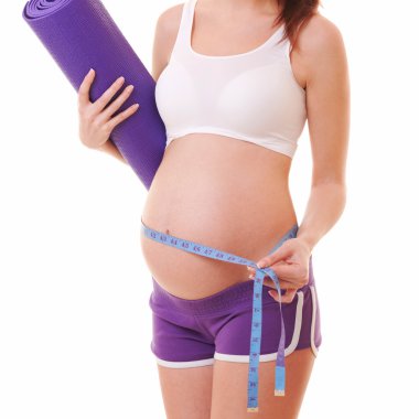 mat ve ölçü birimi teyp beyaz arka plan üzerinde egzersiz ile hamile kadın