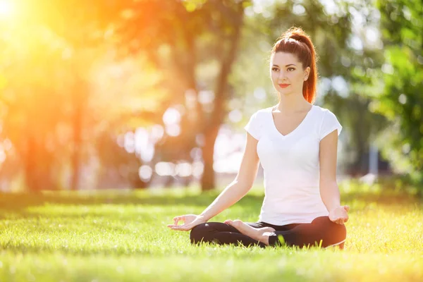 瑜伽在室外 快乐的女人做瑜伽练习 在阳光灿烂的公园冥想 大自然中的瑜珈冥想 健康的生活方式和放松的概念 在草地上练瑜伽的漂亮女人 — 图库照片