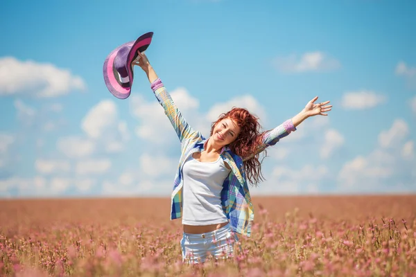 Mujer linda en el campo con flores —  Fotos de Stock