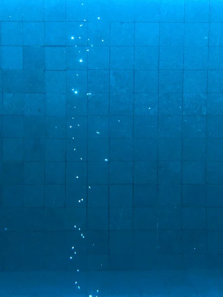 在游泳池下面的气泡 蓝色的瓷砖背衬 — 图库照片