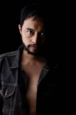 Kot gömlek giyen bir adam, sert bir yüz, sakal. Stüdyo fotoğrafı, siyah sahne, yakın plan, kafa ve yüz.