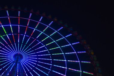 Gece Tokyo 'daki lunaparkta dönme dolap.