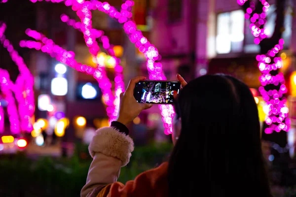 渋谷の夜の街でイルミネーション撮影をしている日本人女の子。 — ストック写真
