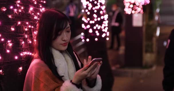 Μια Γιαπωνέζα παίρνει τηλέφωνο τη νύχτα και φωτίζει το δρόμο στη Σιμπούγια. — Αρχείο Βίντεο