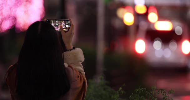 Une fille japonaise tirant sur l'illumination dans la rue de nuit à Shibuya gros plan — Video