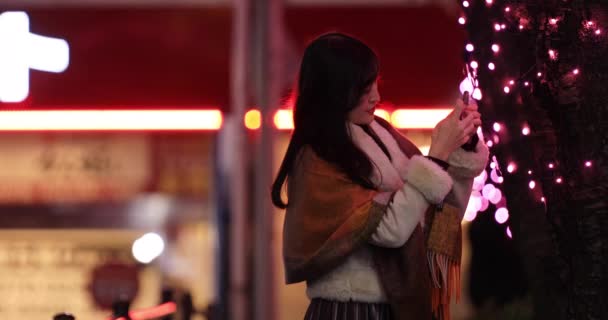 Uma menina japonesa atirando iluminação na rua noturna em Shibuya — Vídeo de Stock