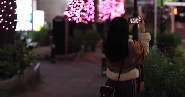 Una chica japonesa disparando iluminación en la calle nocturna de Shibuya — Vídeo de stock