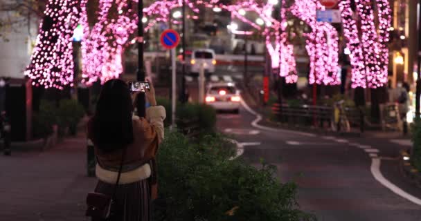 En japansk flicka skjuter belysning på natten gatan i Shibuya — Stockvideo