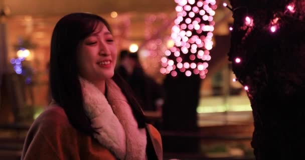 Ein japanisches Mädchen erschießt Beleuchtung in der Nacht Straße in Shibuya Nahaufnahme Handheld — Stockvideo