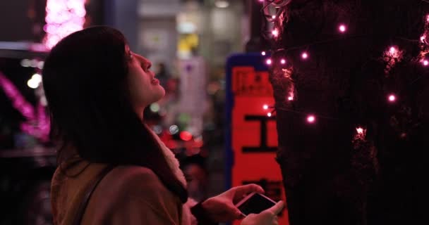 Una chica japonesa disparando iluminación en la calle nocturna de Shibuya de cerca — Vídeo de stock