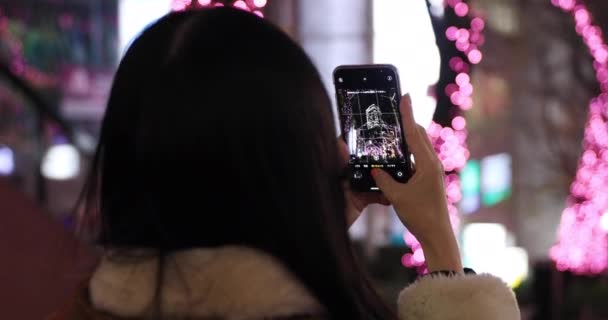 A Japanese girl shooting illumination at the night street in Shibuya close shot handheld — Stock Video