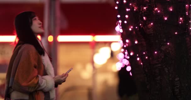 Japonská dívka střílí selfie v noci osvětlené ulici v Shibuya — Stock video