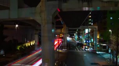Tokyo 'da otoyolun altındaki caddenin gece şeridi geniş açıyla çekiliyor.