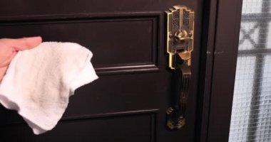 Girişteki kapı tokmağı dezenfekte ediliyor.