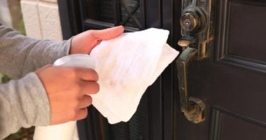 Girişteki kapı tokmağı dezenfekte ediliyor.
