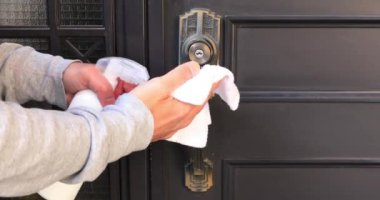 Girişteki kapı tokmağı dezenfekte ediliyor.