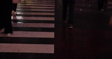 Yağmurlu bir günde Shibuya 'da yürüyen insanların vücut parçalarının yüksek hızda vurulması.