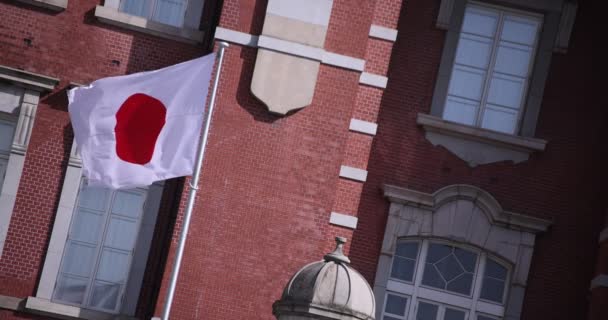 En hög hastighet av japansk nationalflagga runt Tokyo station diagonal sammansättning — Stockvideo