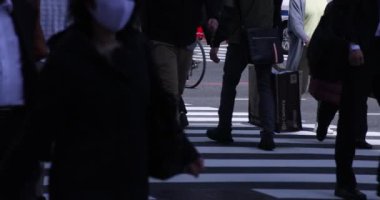 Shinjuku kentindeki yürüyen insanların vücut parçaları yüksek hızda.