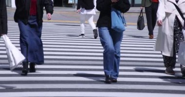 Shinjuku kentindeki yürüyen insanların vücut parçaları yüksek hızda.