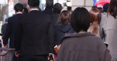 Shinjuku 'daki şehir merkezinde yüksek hızlı yürüyen ofis çalışanları.
