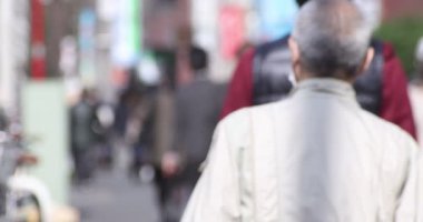 Shinjuku 'daki şehir merkezinde yüksek hızlı yürüyen ofis çalışanları.