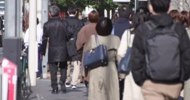Shinjuku 'daki şehir merkezinde yüksek hızlı yürüyen ofis çalışanları.