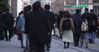 Shinjuku 'daki şehir merkezinde yüksek hızlı yürüyen ofis çalışanları.