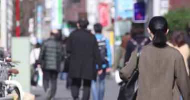 Shinjuku 'daki şehir merkezinde yüksek hızlı yürüyen ofis çalışanları.