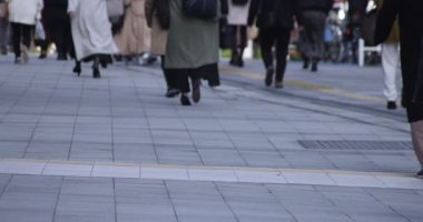 Shinjuku kentindeki yürüyen insanların vücut parçaları yüksek hızda.