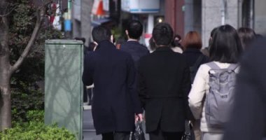 Shinjuku 'daki şehir merkezinde yüksek hızlı yürüyen ofis çalışanları.