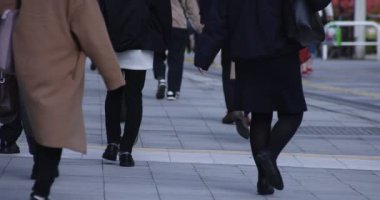 Shinjuku kentindeki yürüyen insanların vücut parçaları yüksek hızda.