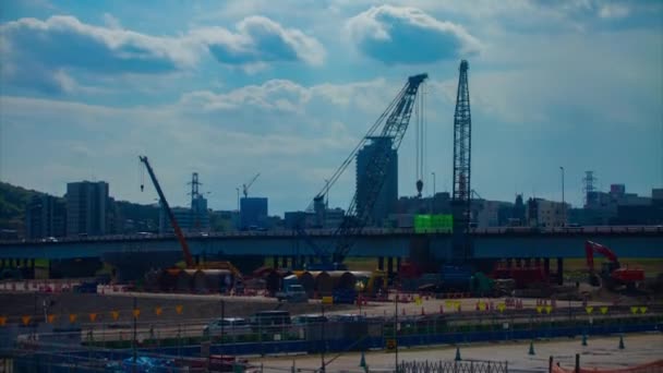 Un timelapse de grúas móviles en la inclinación diurna en construcción — Vídeo de stock