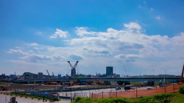 Un timelapse de grúas en movimiento en la construcción durante el día panorámica de tiro ancho — Vídeos de Stock