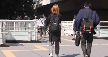 Shibuya 'daki şehir şehrinde yürüyen insanların yavaş çekimleri.