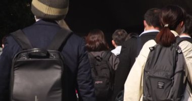 Shibuya 'daki şehir şehrinde yürüyen insanların yavaş çekimleri.