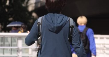 Shibuya 'daki şehir şehrinde yürüyen insanların yavaş çekimleri.