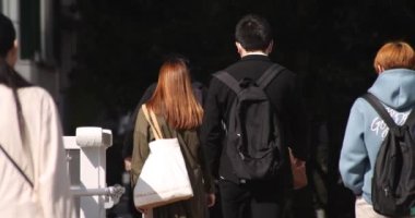 Shibuya 'daki şehir şehrinde yürüyen insanların yavaş çekimleri.