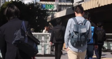 Shibuya 'daki şehir şehrinde yürüyen insanların yavaş çekimleri.