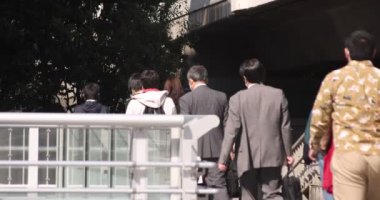 Shibuya 'daki şehir şehrinde yürüyen insanların yavaş çekimleri.